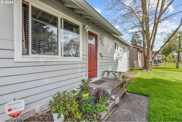 view of exterior entry with a lawn