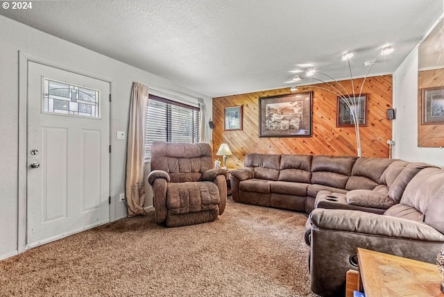 carpeted living room featuring wooden walls and a textured ceiling