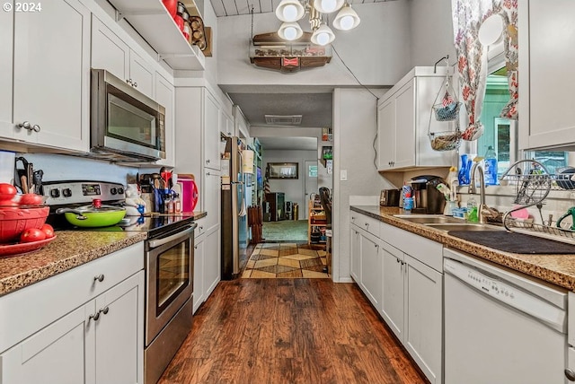 kitchen with white cabinets, sink, dark hardwood / wood-style floors, light stone countertops, and stainless steel appliances