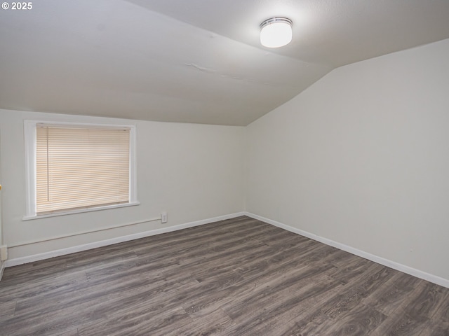 bonus room with vaulted ceiling and dark wood-type flooring