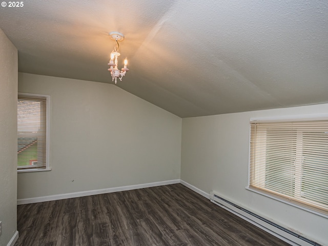 additional living space featuring a textured ceiling, dark wood-type flooring, baseboard heating, and vaulted ceiling