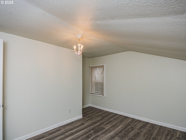 bonus room featuring a textured ceiling, dark wood-type flooring, vaulted ceiling, and a notable chandelier