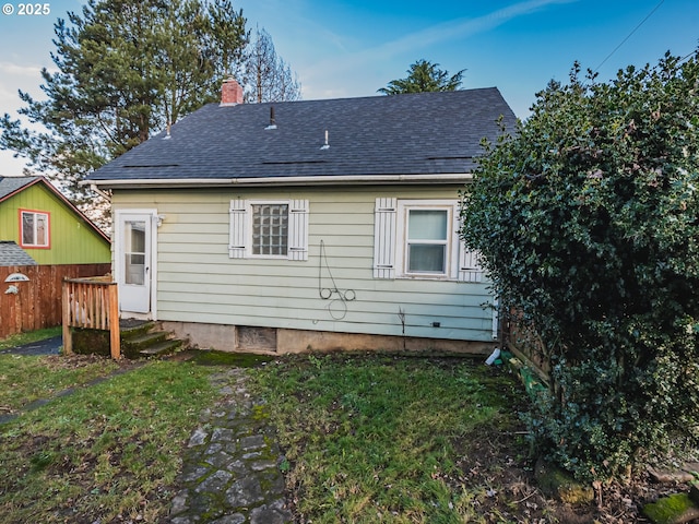 rear view of property featuring a yard