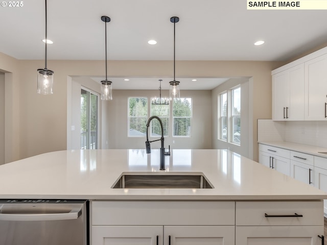 kitchen featuring stainless steel dishwasher, light countertops, a wealth of natural light, and a sink