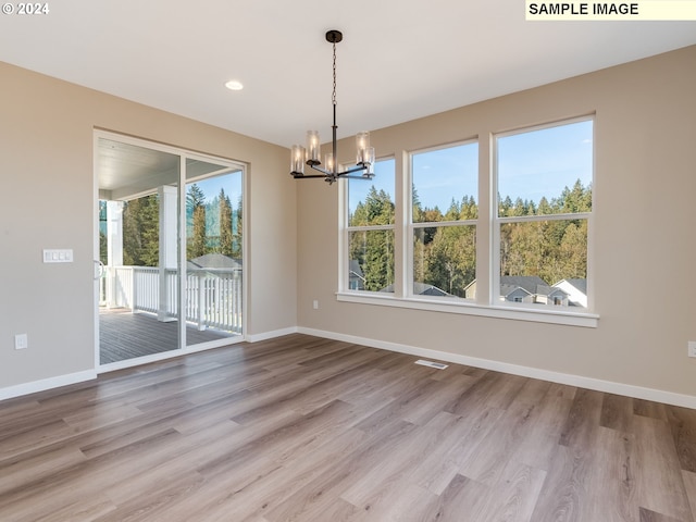 unfurnished dining area with a wealth of natural light, baseboards, and wood finished floors