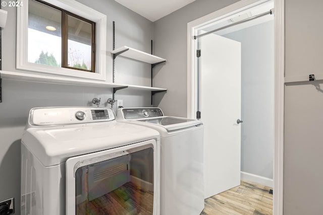 clothes washing area featuring light hardwood / wood-style floors and independent washer and dryer