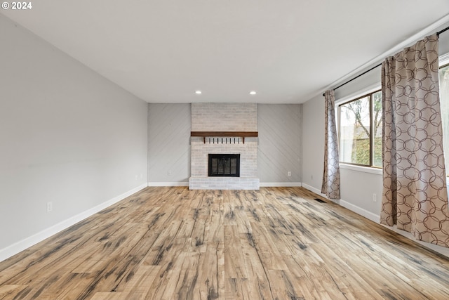 unfurnished living room featuring a fireplace and light hardwood / wood-style flooring