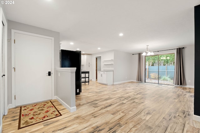 living room with an inviting chandelier and light hardwood / wood-style flooring