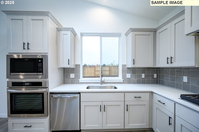 kitchen featuring tasteful backsplash, white cabinetry, sink, and appliances with stainless steel finishes