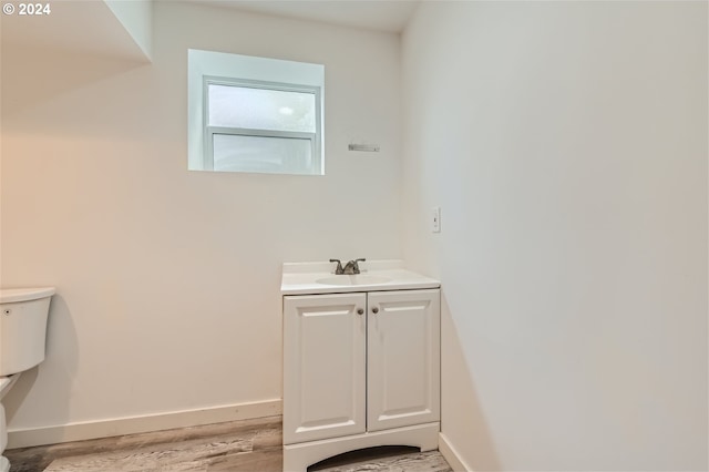 bathroom with vanity, wood-type flooring, and toilet