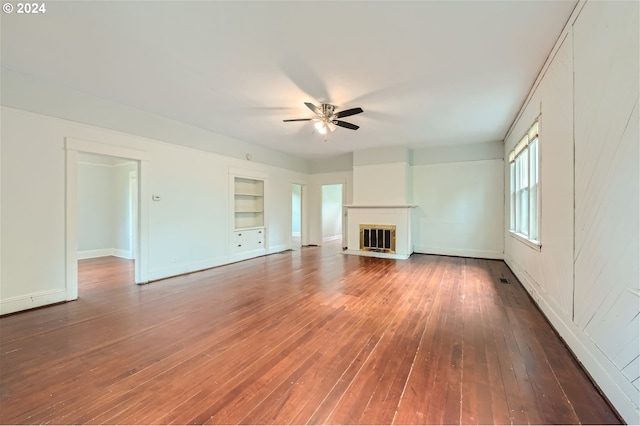 unfurnished living room with hardwood / wood-style flooring, built in features, and ceiling fan