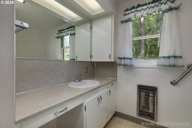 bathroom with vanity, tasteful backsplash, and heating unit