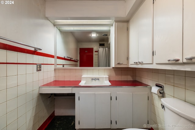 bathroom with toilet, vanity, and decorative backsplash