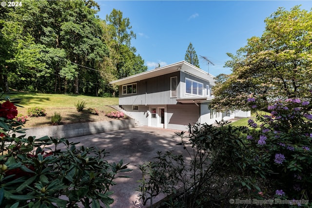 view of side of home featuring a patio and a yard