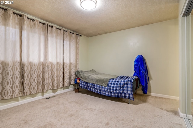 bedroom featuring a textured ceiling and carpet flooring