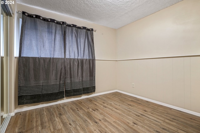 spare room with wood-type flooring and a textured ceiling