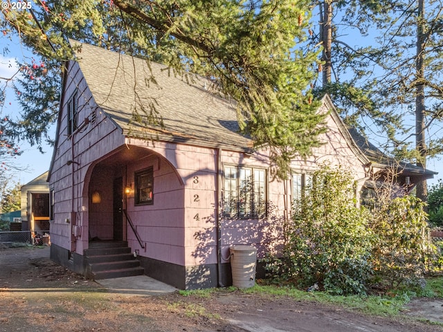 tudor-style house featuring roof with shingles