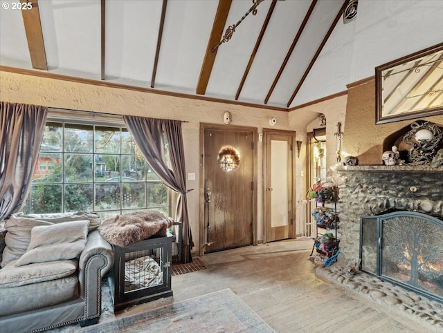 unfurnished living room with lofted ceiling with beams, wood-type flooring, and a brick fireplace