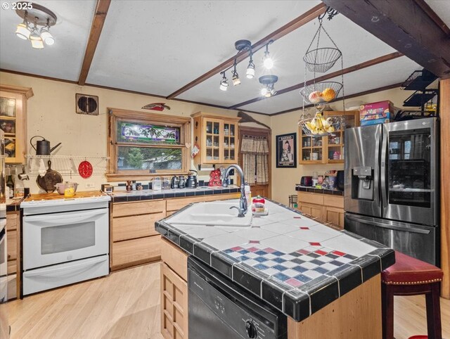 kitchen with tile countertops, light hardwood / wood-style floors, black appliances, and an island with sink