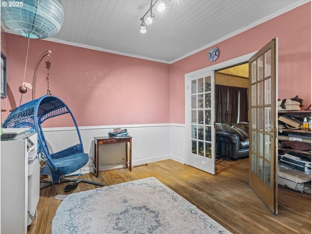 living area with light hardwood / wood-style flooring, a wealth of natural light, ornamental molding, and a notable chandelier