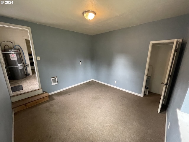 unfurnished bedroom featuring strapped water heater and dark colored carpet