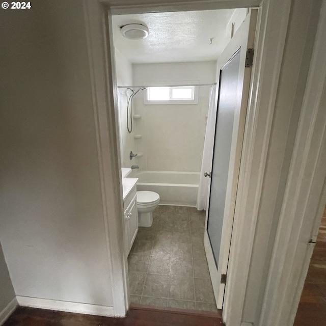 full bathroom with vanity, tile patterned floors, tub / shower combination, toilet, and a textured ceiling