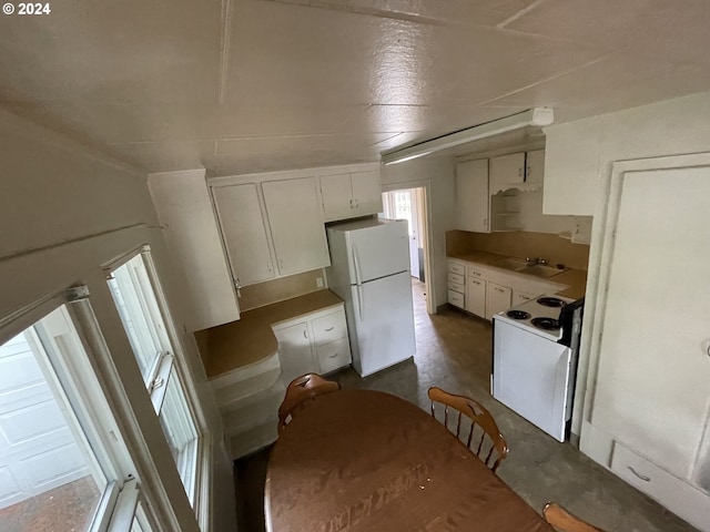 kitchen with sink, white cabinets, and white appliances