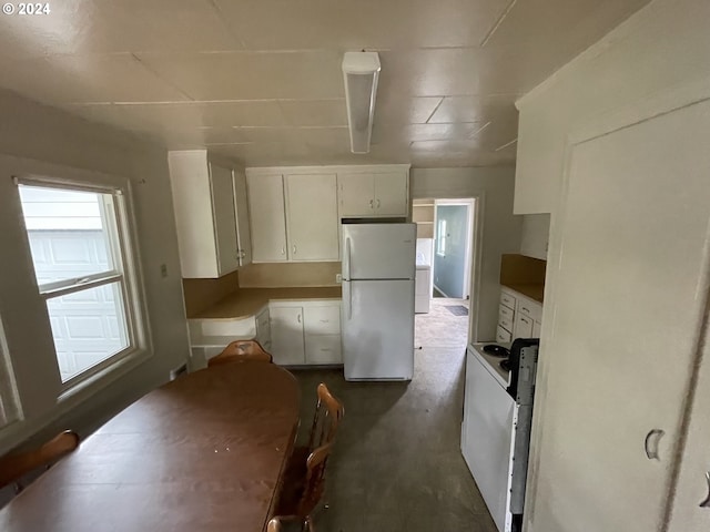 kitchen featuring white cabinetry and white fridge