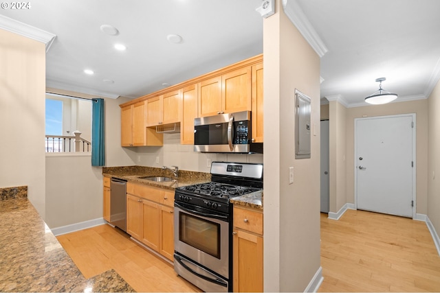 kitchen featuring appliances with stainless steel finishes, light wood-type flooring, light brown cabinets, and sink