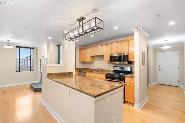 kitchen with sink, hanging light fixtures, ornamental molding, kitchen peninsula, and stainless steel appliances