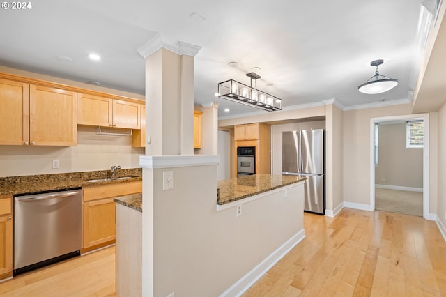 kitchen with appliances with stainless steel finishes, ornamental molding, sink, light brown cabinets, and decorative light fixtures