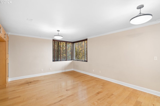 empty room with light hardwood / wood-style floors and ornamental molding