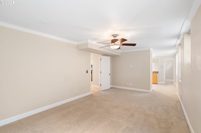 carpeted spare room with ceiling fan and crown molding