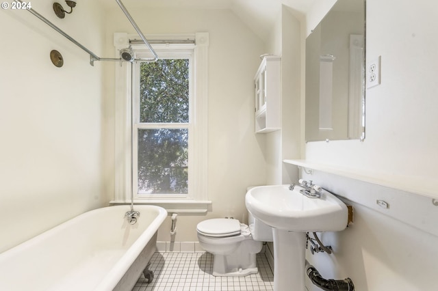 bathroom featuring a bathing tub, tile patterned flooring, and toilet