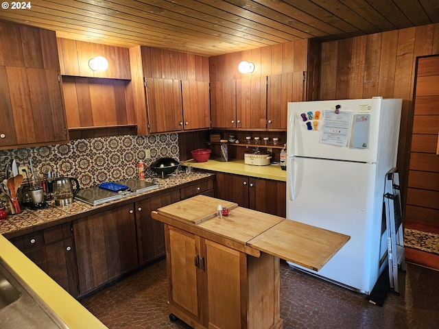 kitchen featuring a center island, wooden walls, white fridge, decorative backsplash, and wood ceiling