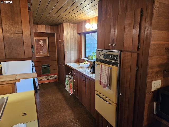 kitchen with wood walls, oven, wooden ceiling, and white refrigerator