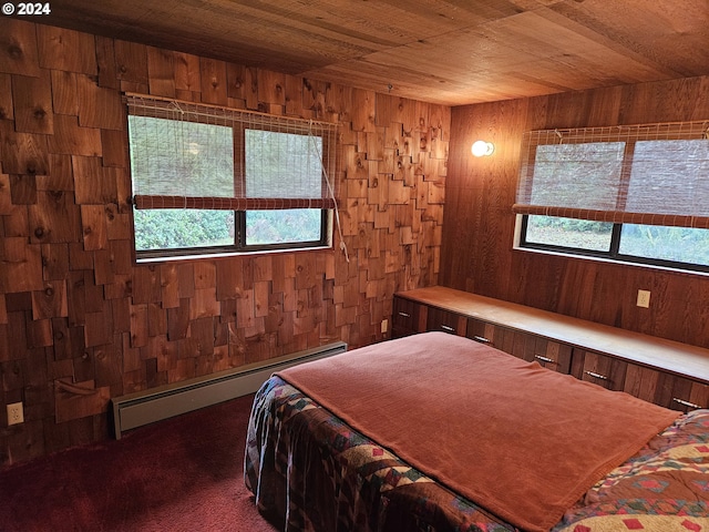 bedroom featuring dark colored carpet, baseboard heating, wooden ceiling, and wood walls