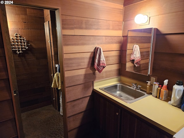 bathroom featuring vanity and wooden walls