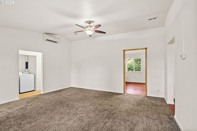 carpeted empty room with washer / clothes dryer, a wall unit AC, and ceiling fan