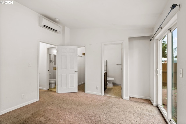 unfurnished bedroom featuring light colored carpet, ensuite bath, lofted ceiling, and a wall unit AC