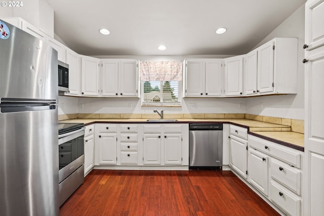 kitchen featuring dark hardwood / wood-style flooring, white cabinets, and appliances with stainless steel finishes