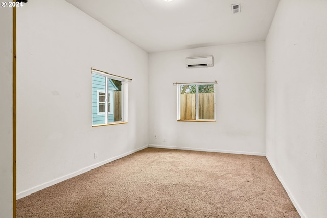 unfurnished room with an AC wall unit and carpet floors