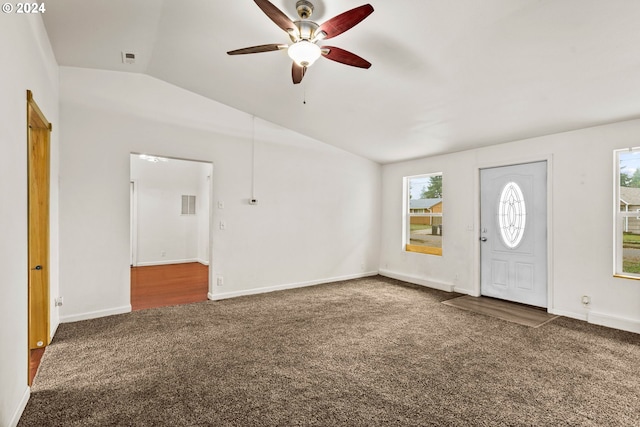 entryway featuring dark colored carpet, vaulted ceiling, plenty of natural light, and ceiling fan