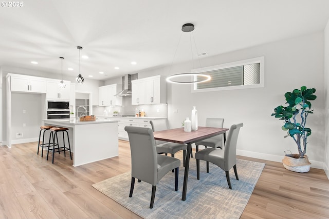 dining area with light wood-type flooring and sink