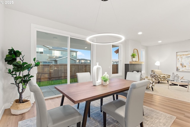 dining room with hardwood / wood-style flooring and a tiled fireplace