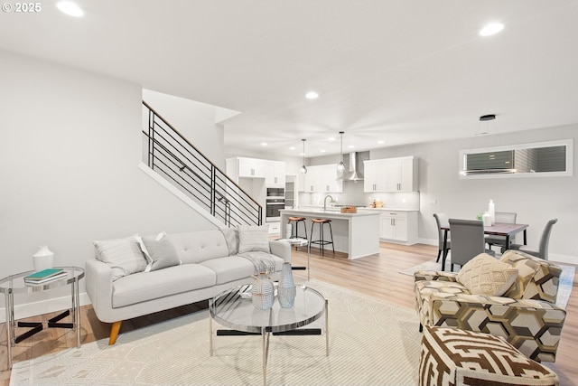 living room with sink and light hardwood / wood-style flooring