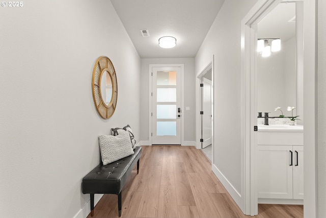 doorway with light wood-type flooring and sink