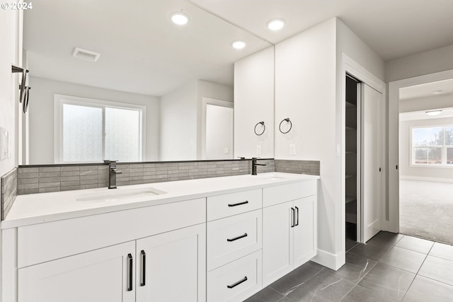 bathroom featuring decorative backsplash, vanity, and tile patterned flooring