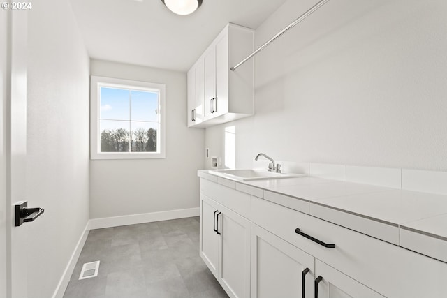 laundry room featuring sink, washer hookup, and cabinets