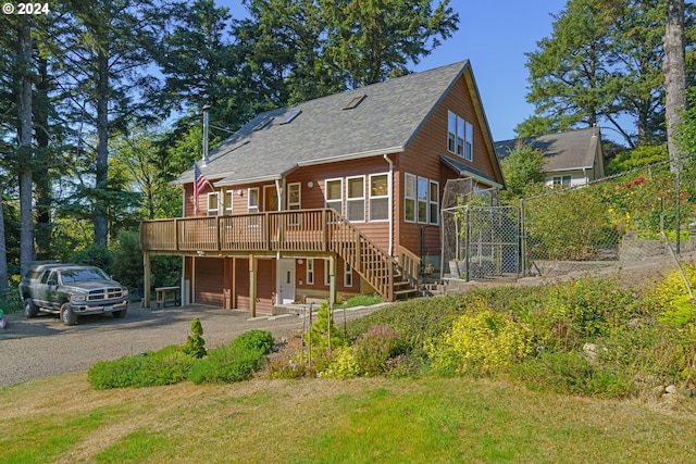 back of house featuring a lawn and a deck